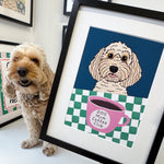 Dog standing next to a framed illustration of a dog with a coffee cup on a checkered background.