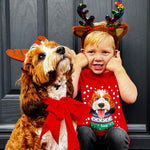 Child and dog wearing reindeer hats with a festive background