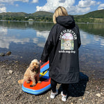 Person and dog by a lake with a scenic background