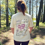Person wearing a 'Feel Good Walking Club' t-shirt in a forest setting