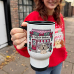 Person holding a mug with a design of a dog and text, standing on a street.