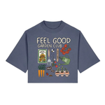 Blue t-shirt with 'Feel Good Garden Club' design featuring gardening elements on a white background.
